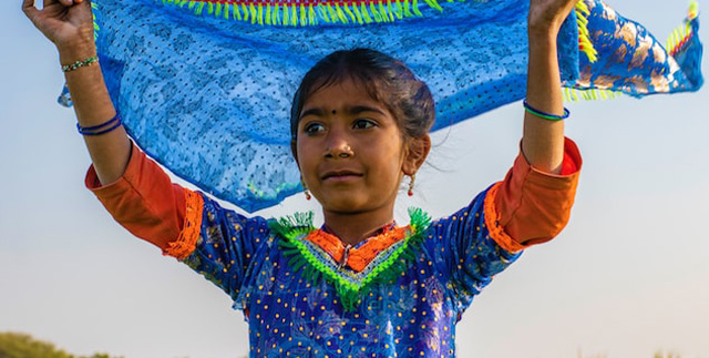 Menina paquistanesa com lenço ao ar